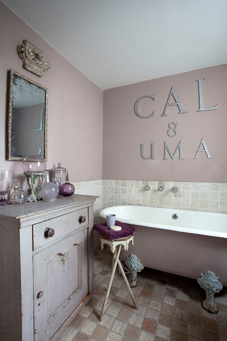 Freistehende Badewanne mit Schriftzug in gedämpften Mauvetönen, Stadthaus in London, England, Vereinigtes Königreich