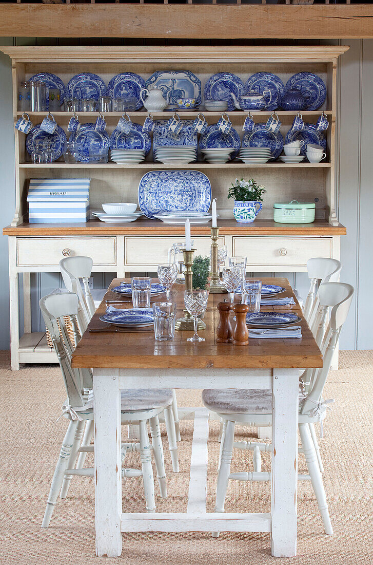 Esstisch für vier Personen mit blauem und weißem Porzellan in einer Küchenkommode in einem Bauernhaus in Kent, England UK