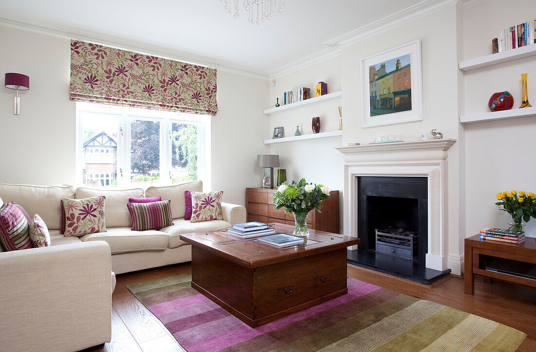 Geblümte Jalousien in Kombination mit Kissenstoff im modernen Wohnzimmer eines Familienhauses in Herefordshire, England, UK