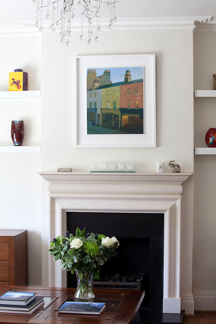 Moderne Kunst über dem Kamin mit Schnittblumen in einem modernen Einfamilienhaus in Herefordshire England UK