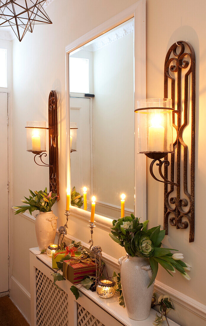Lit antique lanterns and hallway mirror at Christmas in London home, UK