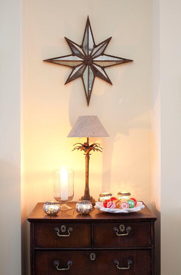 Star shaped wall decoration above antique wooden chest of drawers in London home, UK