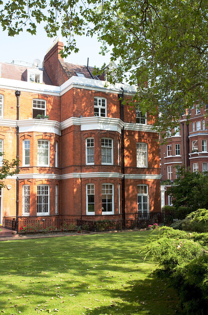Dreistöckiges Londoner Wohnhaus aus Backstein in sonnigem Gelände, England, UK