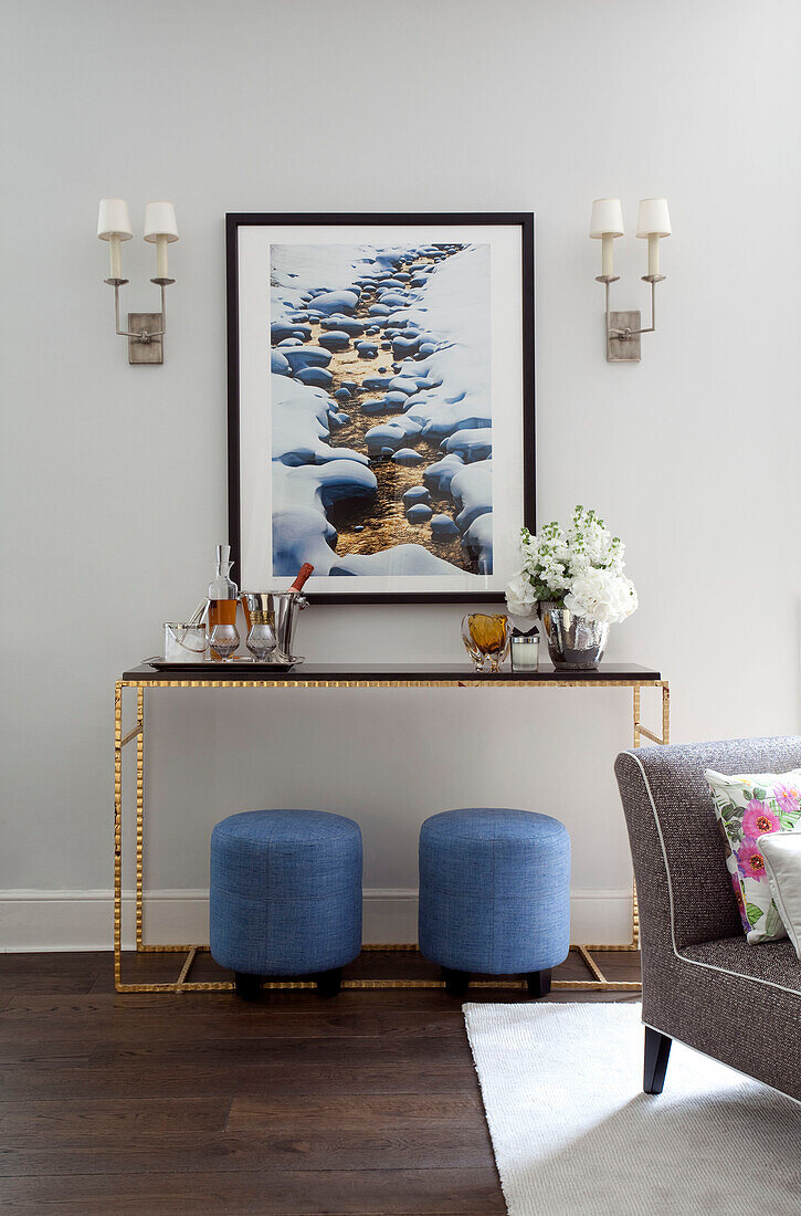 Modern art with light blue footstools and console in London apartment, UK