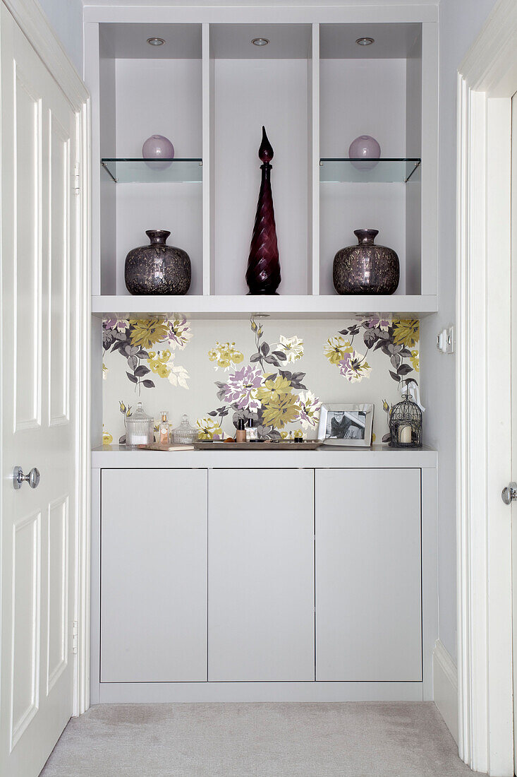 Floral wallpapered recessed shelving in London apartment, UK