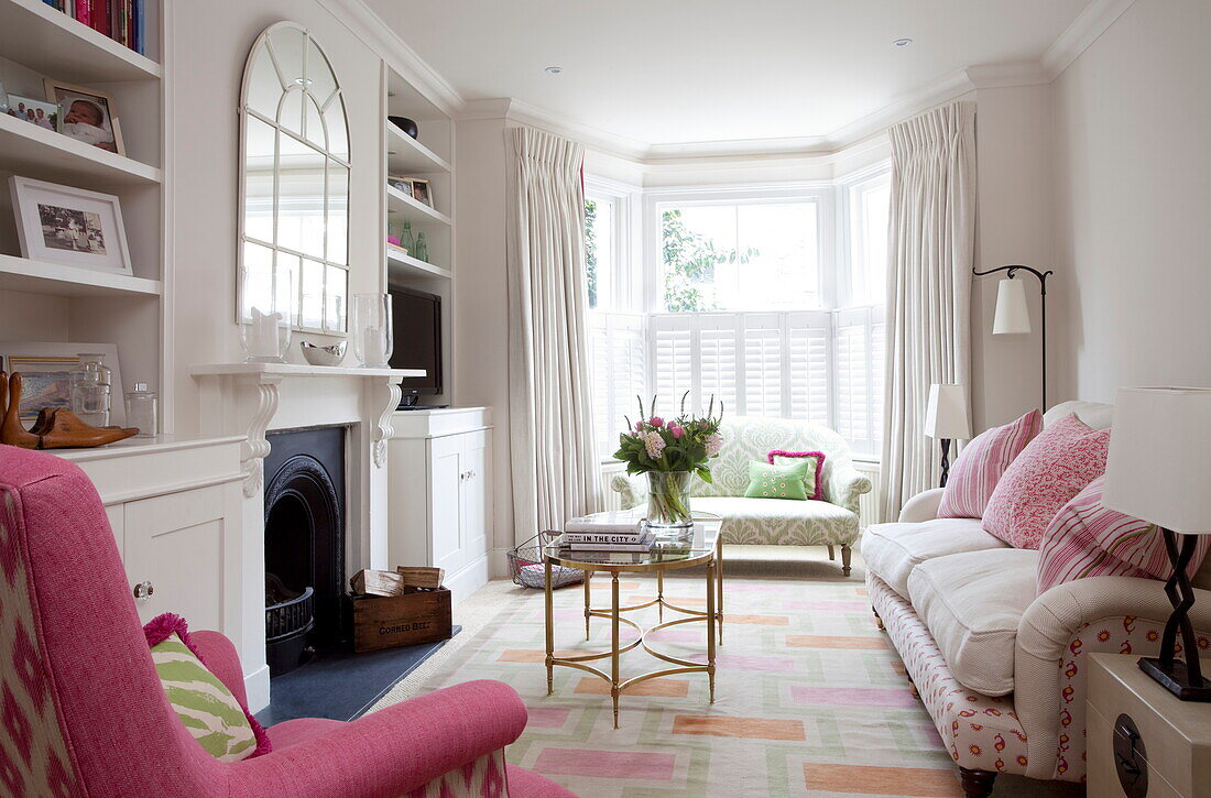 Brass vintage coffee table with pink armchair in living room of London townhouse, England, UK