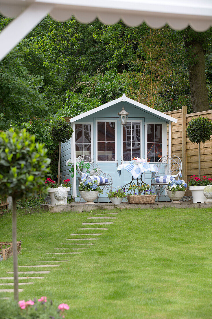 Light blue summerhouse at end of garden path, Dulwich, London, UK