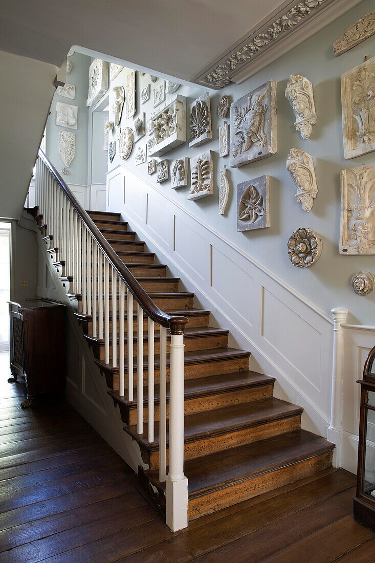 Historic plaster wall mounts on wooden staircase of historic Sussex home England UK