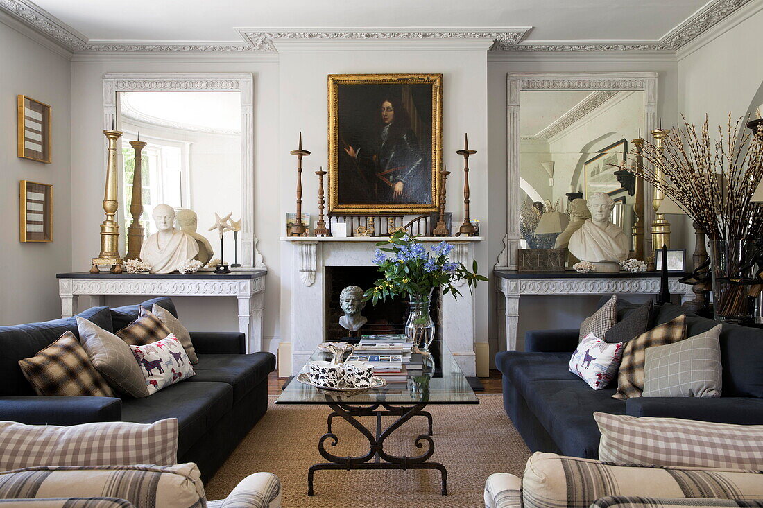 Dark grey sofas with recessed console tables and mirrors in historic Sussex country home England UK
