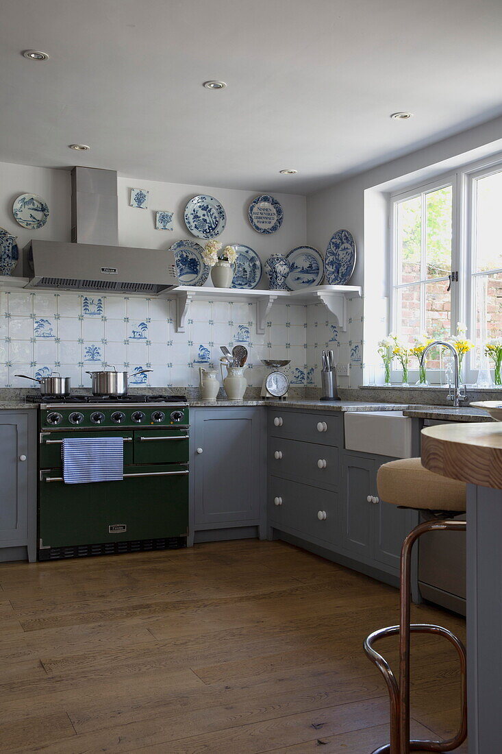 Pastellblaue Einbauküche mit grünem Herd in historischem Landhaus in Sussex (England)