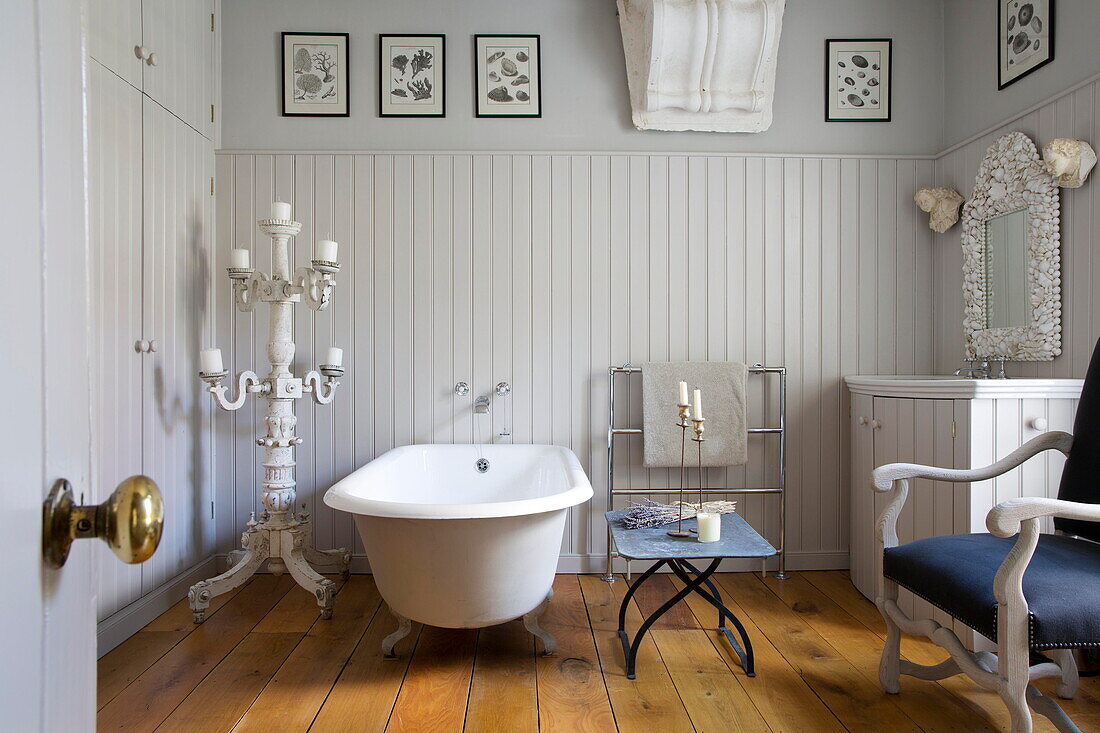 Freistehende Badewanne mit bemaltem Kandelaber in einem historischen Landhaus in Sussex England UK