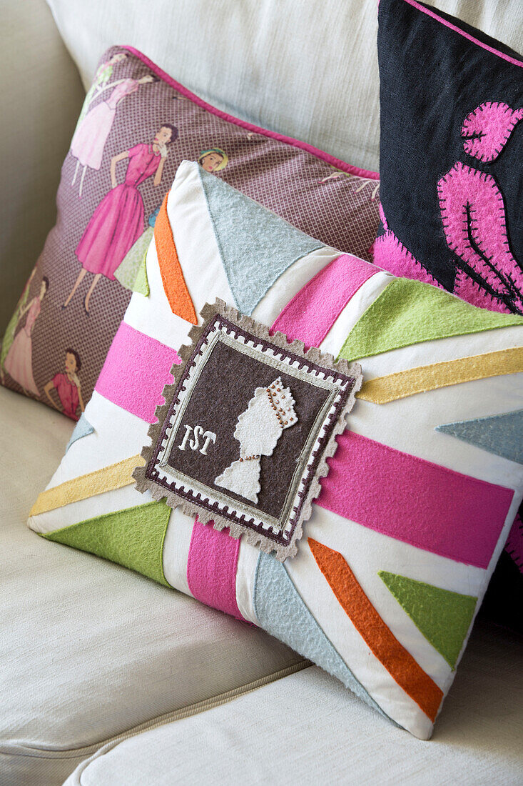 Union-Jack-Kissen mit Briefmarke auf Sofa in Haus in Sussex, England, UK