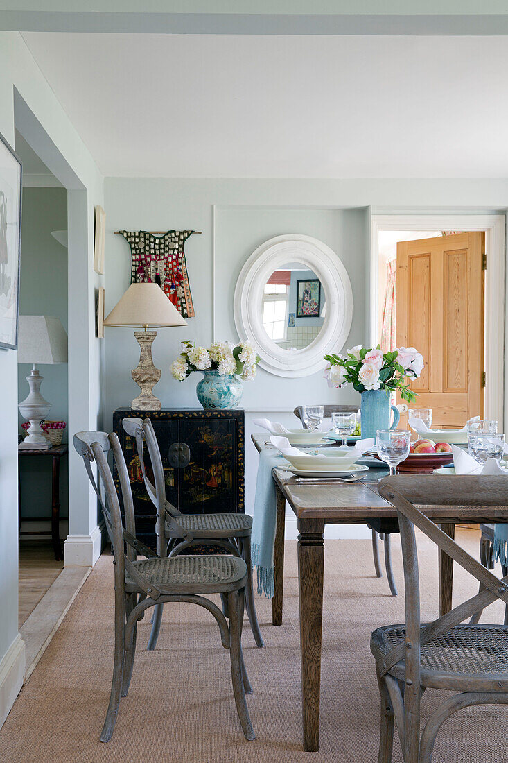 Wicker chairs at dining table in Sussex home, England, UK