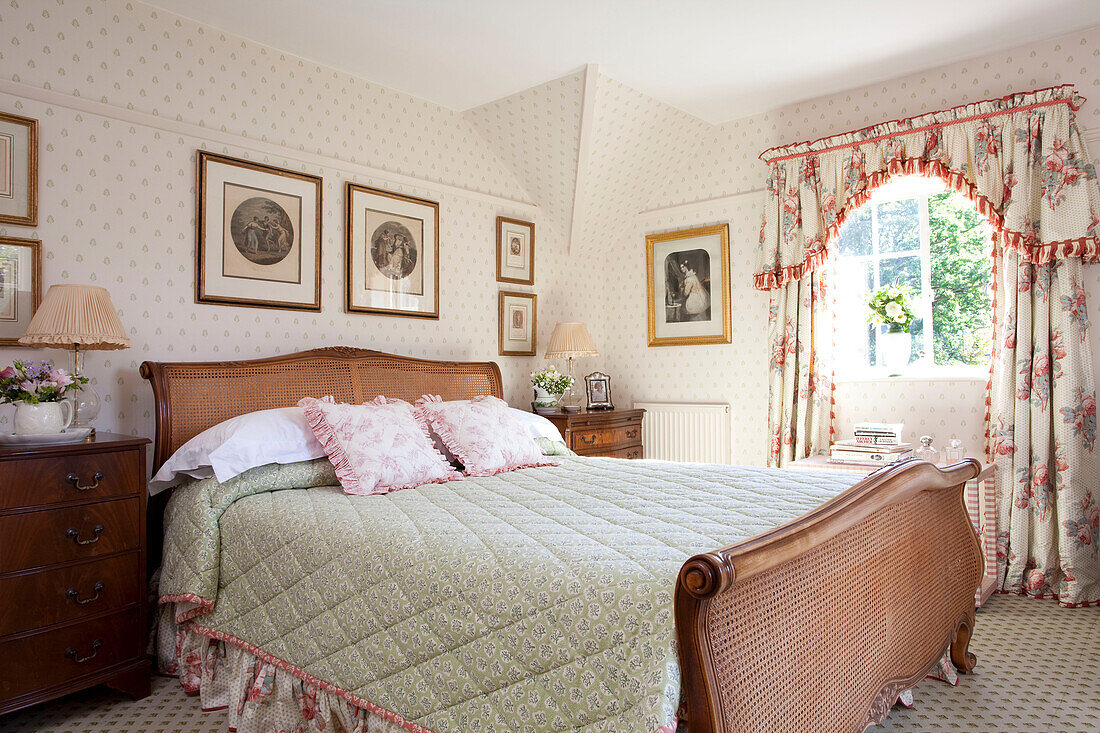 Antikes Korbbett in einem sonnenbeschienenen Schlafzimmer in einem Bauernhaus in Sussex, England, Vereinigtes Königreich