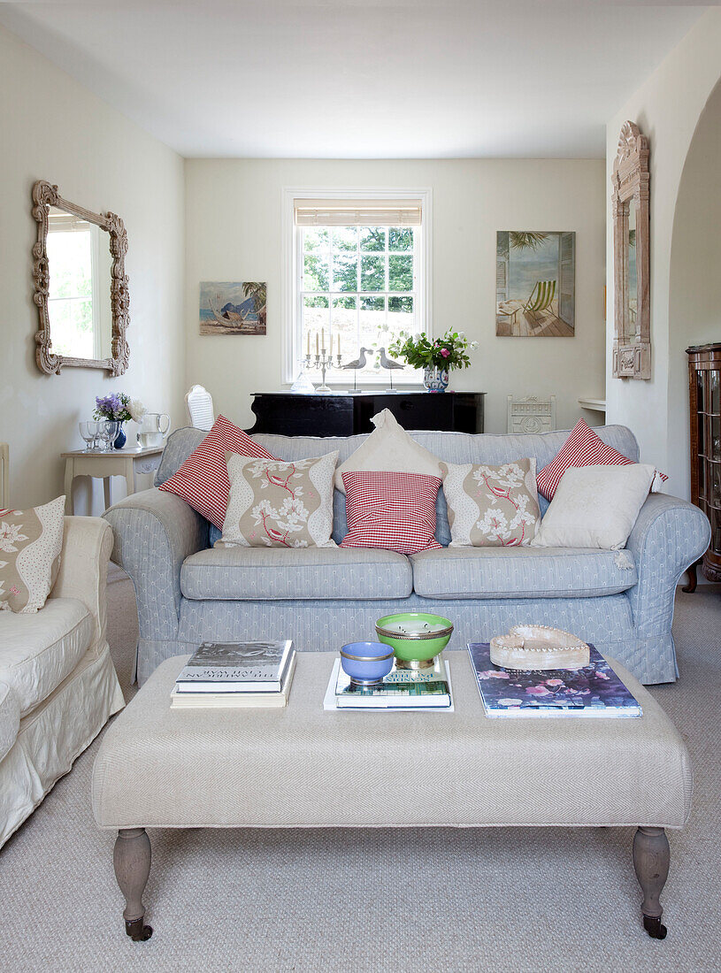 Light blue sofa and ottoman in living room of Sussex cottage, England, UK