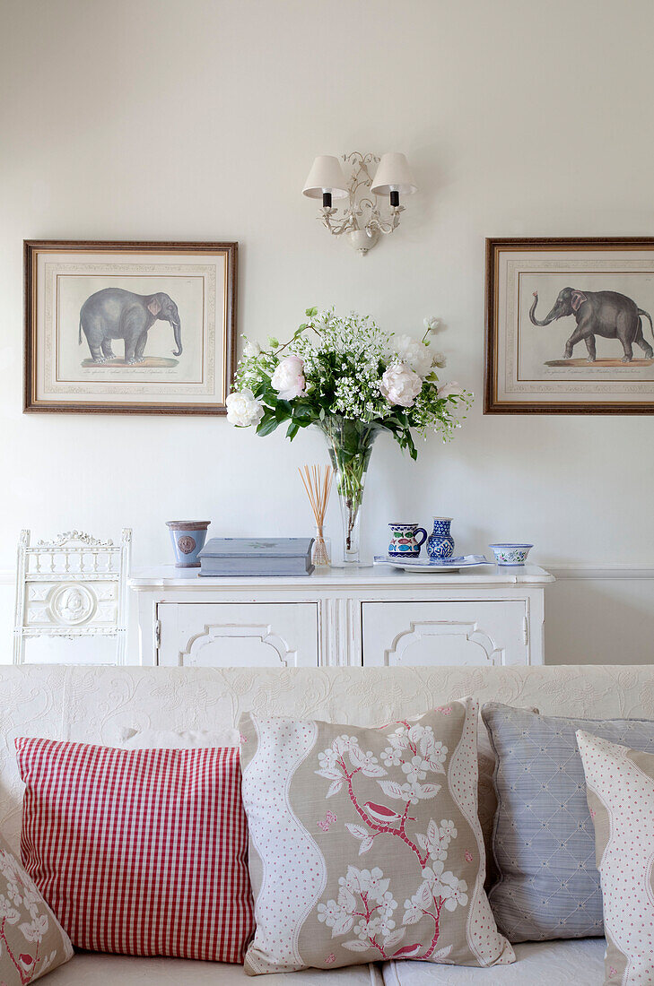 Elefantenkunstwerk und Schnittrosen im Wohnzimmer eines Landhauses in Sussex, England, UK