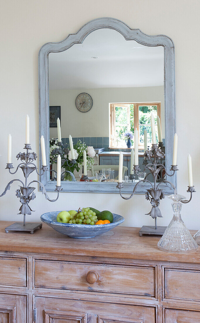 Hellblauer Spiegelrahmen über hölzernem Sideboard in einem Cottage in Sussex, England, UK