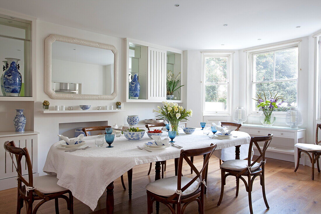 Wooden dining table and chairs in contemporary London townhouse, England, UK