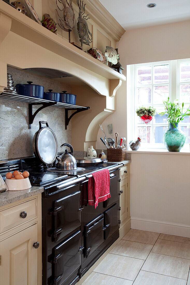 Wasserkocher auf schwarzem Herd in der Küche eines Bauernhauses in Surrey, England, Vereinigtes Königreich