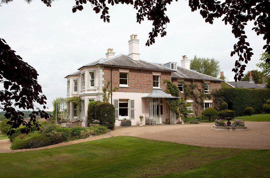Kiesauffahrt und Rasen eines freistehenden Landhauses in Sussex auf eigenem Grundstück, England, Vereinigtes Königreich