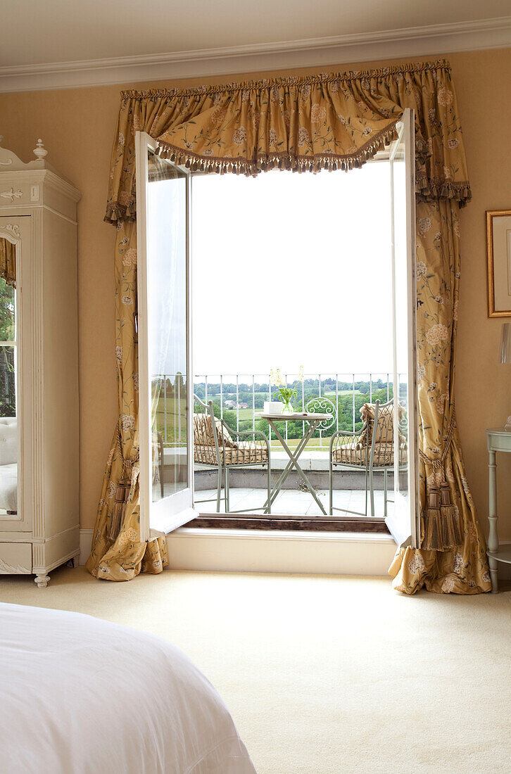 View through open doors to balcony exterior of Sussex country house, England, UK