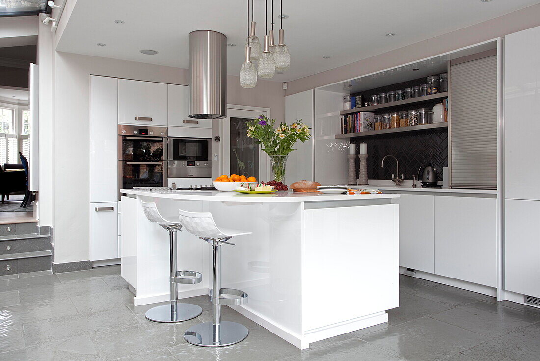 Weiße Split-Level-Küche mit Dunstabzugshaube aus Edelstahl in einem Stadthaus in London, England, UK