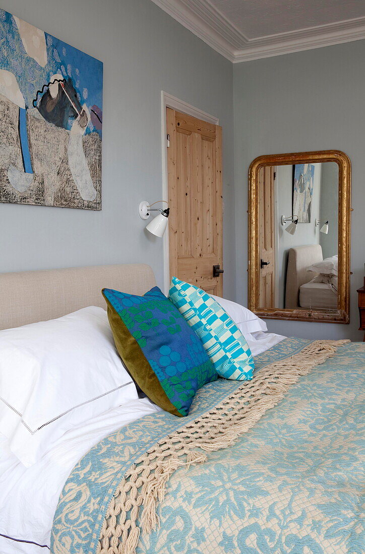 Spiegel mit vergoldetem Rahmen in einem Doppelzimmer mit Kunstwerk in einem Familienhaus in Kent, England UK
