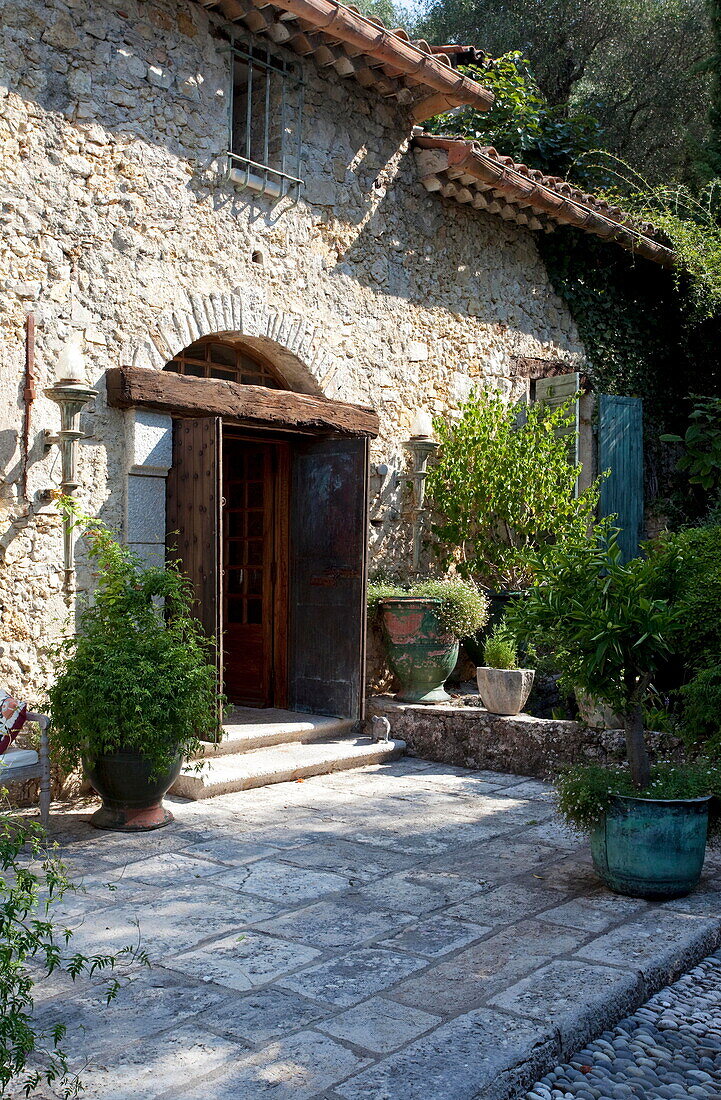 Hölzerne Eingangstür mit Terrasse zu einer französischen Ferienvilla aus Stein
