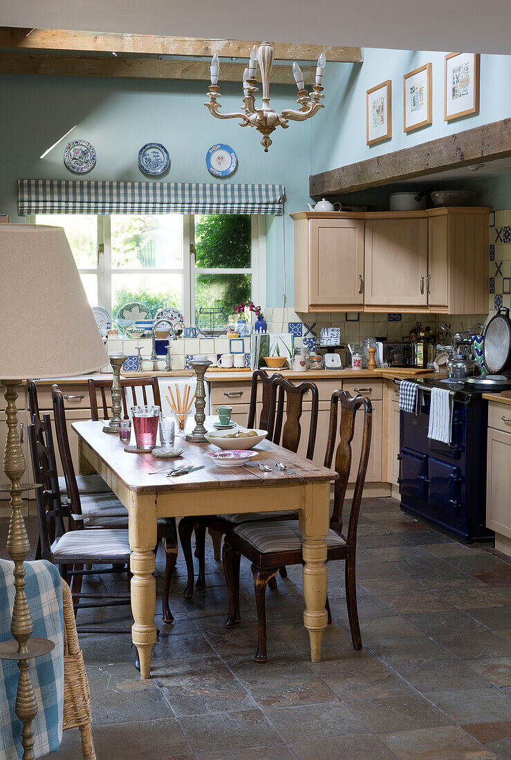 Wooden dining table and chairs in kitchen of Dorset cottage interior, England, UK