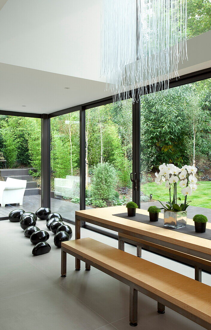 Polished stones and wooden dining table at windows in luxury new build, Kingston upon Thames, England, UK