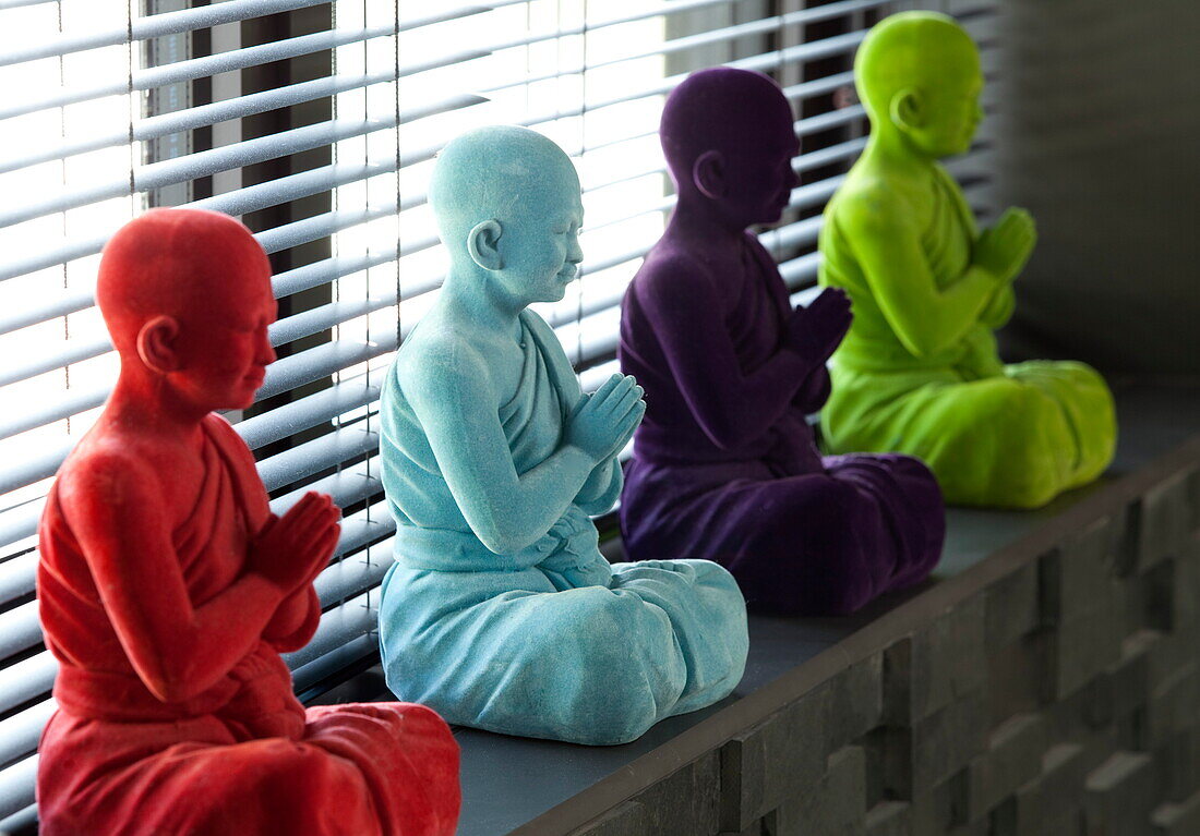 Statues of monks sitting in prayer on windowsill of contemporary home in Kingston upon Thames, England, UK