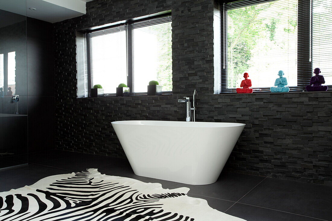 Freistehende Badewanne mit Teppich mit Zebramuster in einem modernen Haus, Kingston upon Thames, England, UK