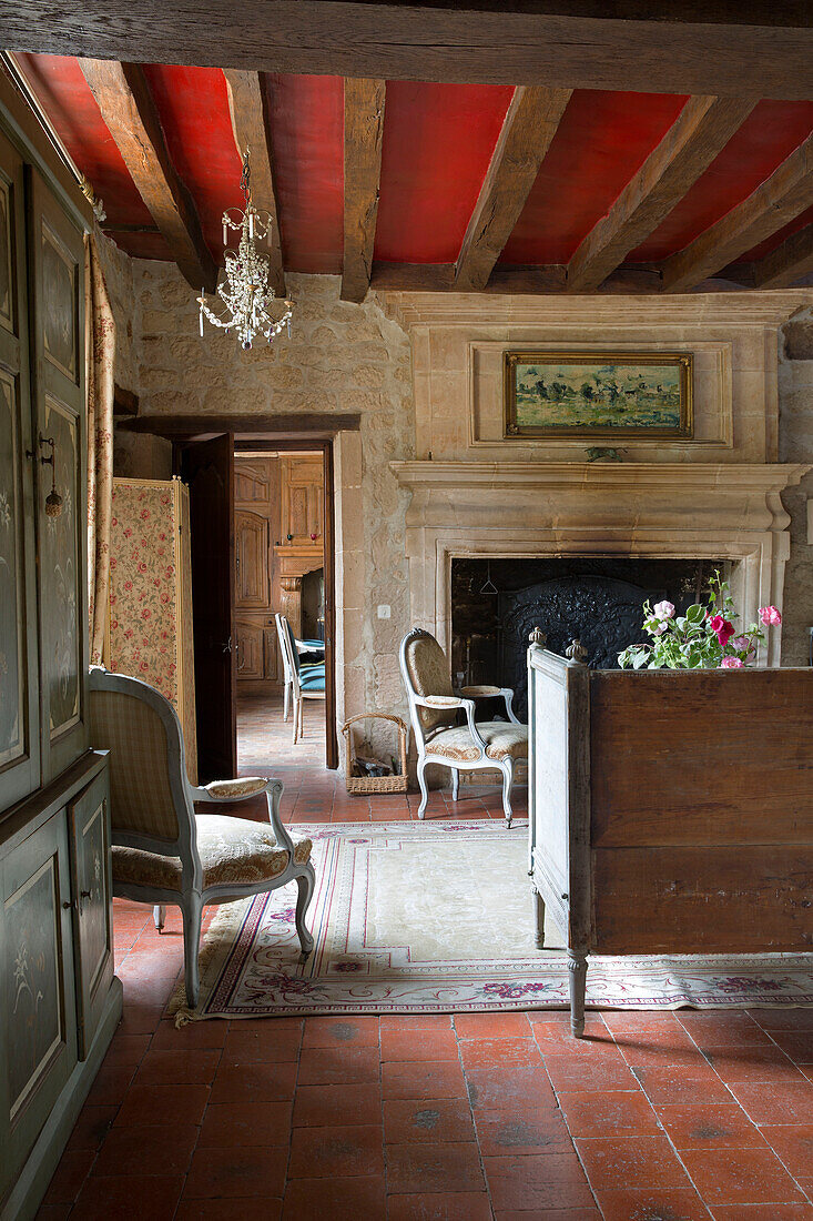Red beamed ceiling in exposed stone living room of French farmhouse in the Loire, France, Europe