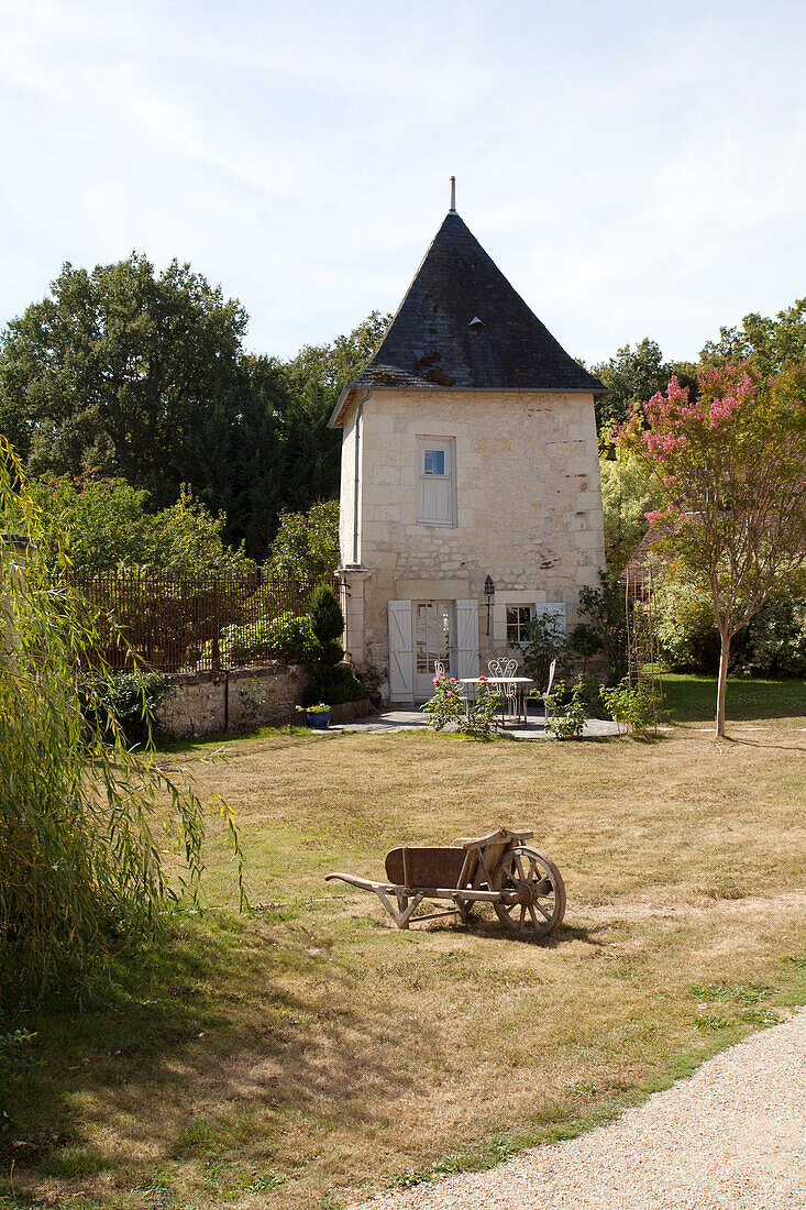 Wooden wheelbarrow in ground of French gatehouse in the Loire, France