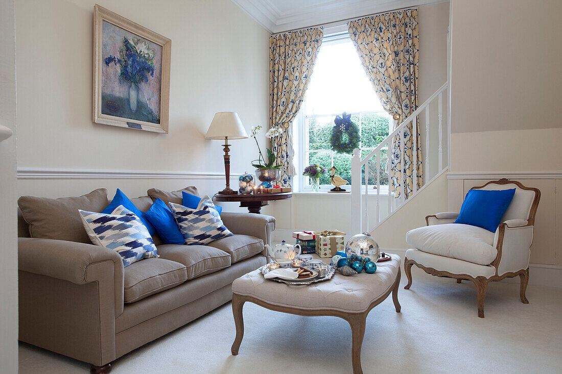 Bright blue cushions on armchair and sofa in living room of West Sussex home England UK