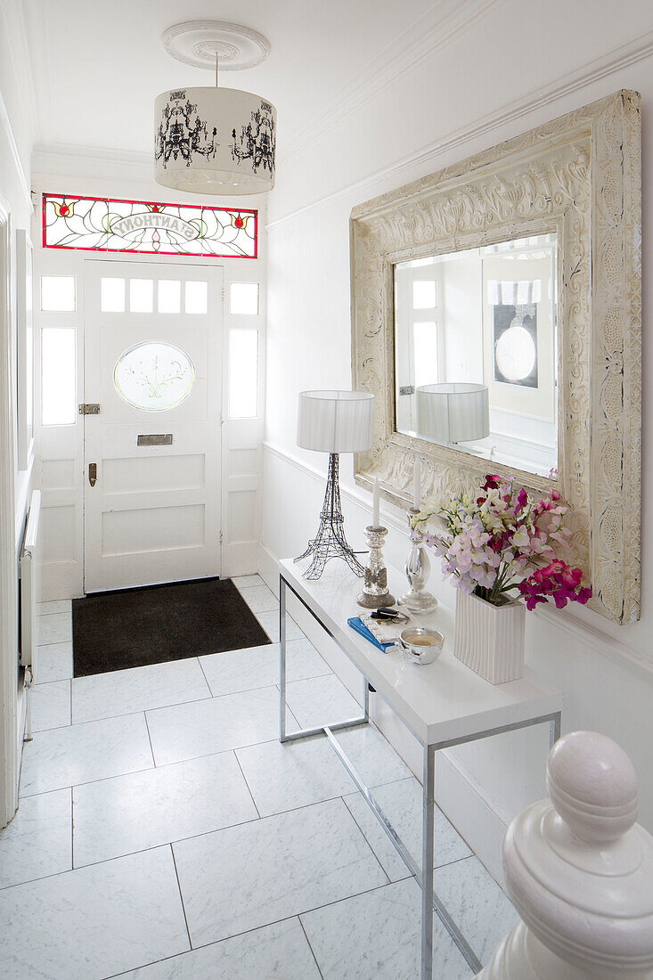 White tiled hallway entrance with large mirror in London townhouse, England, UK