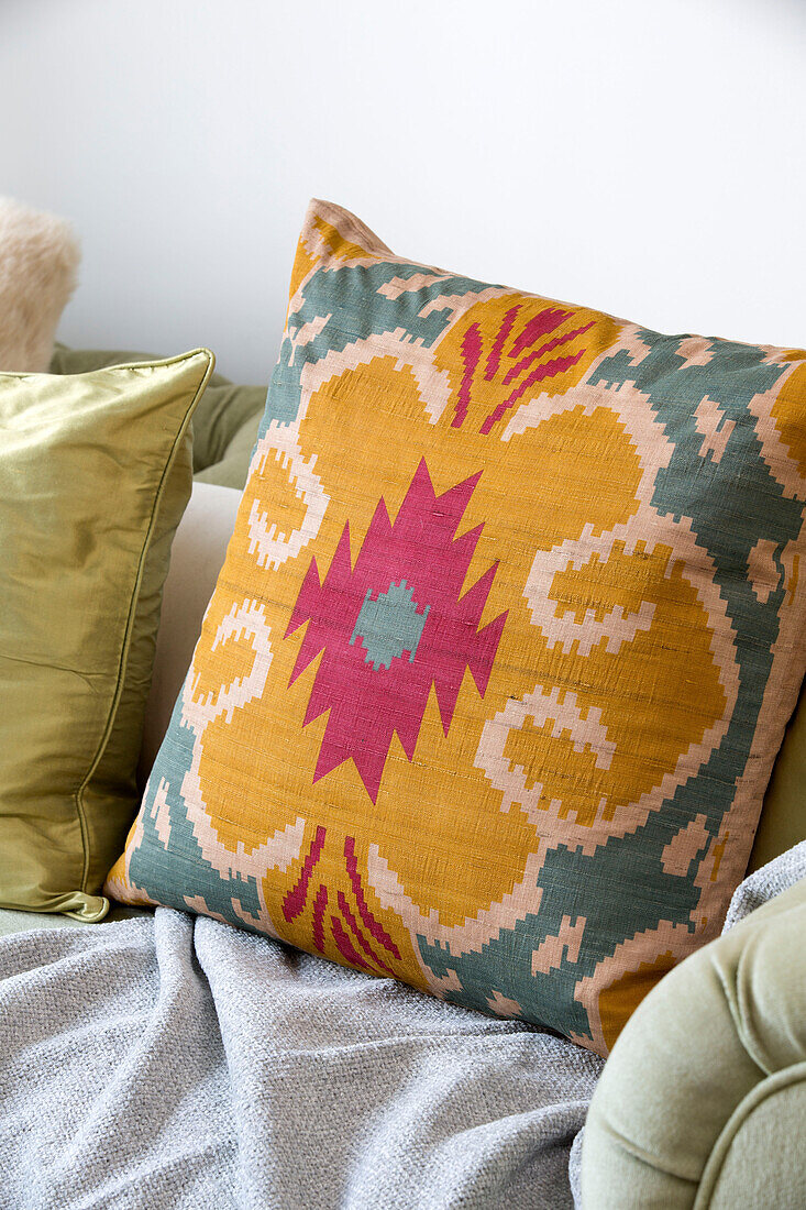 Floral pink and yellow cushion on sofa in London townhouse, England, UK