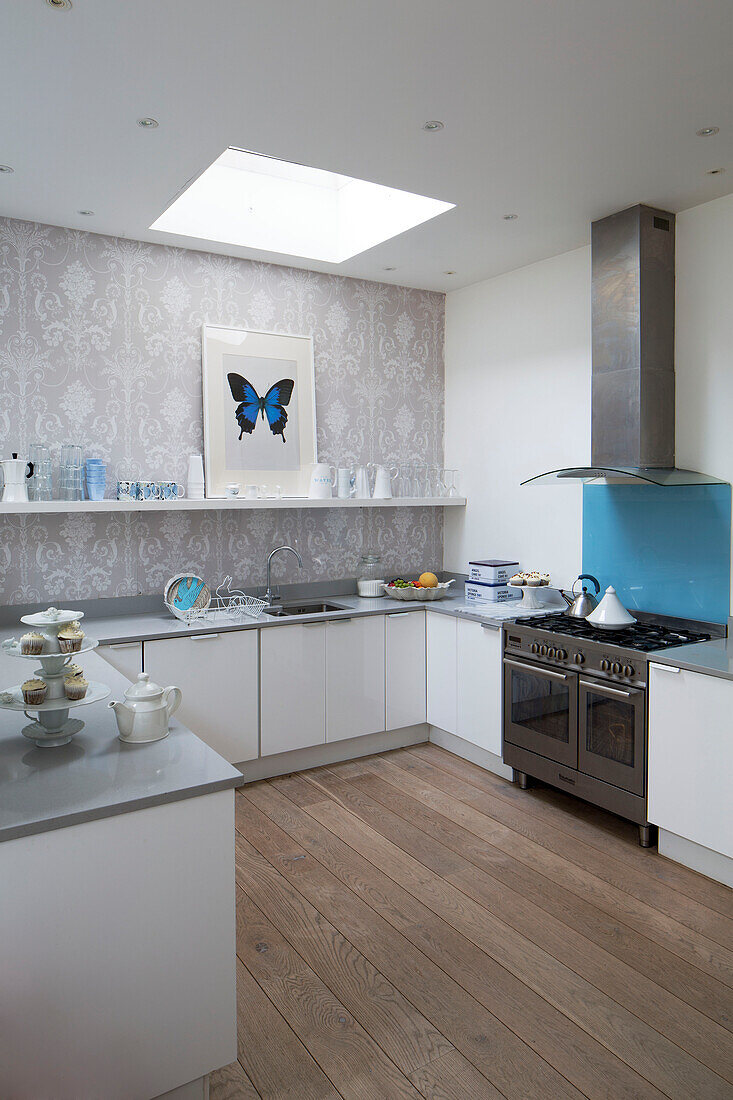 Butterfly print in white fitted kitchen skylight and wooden floor in London townhouse, England, UK