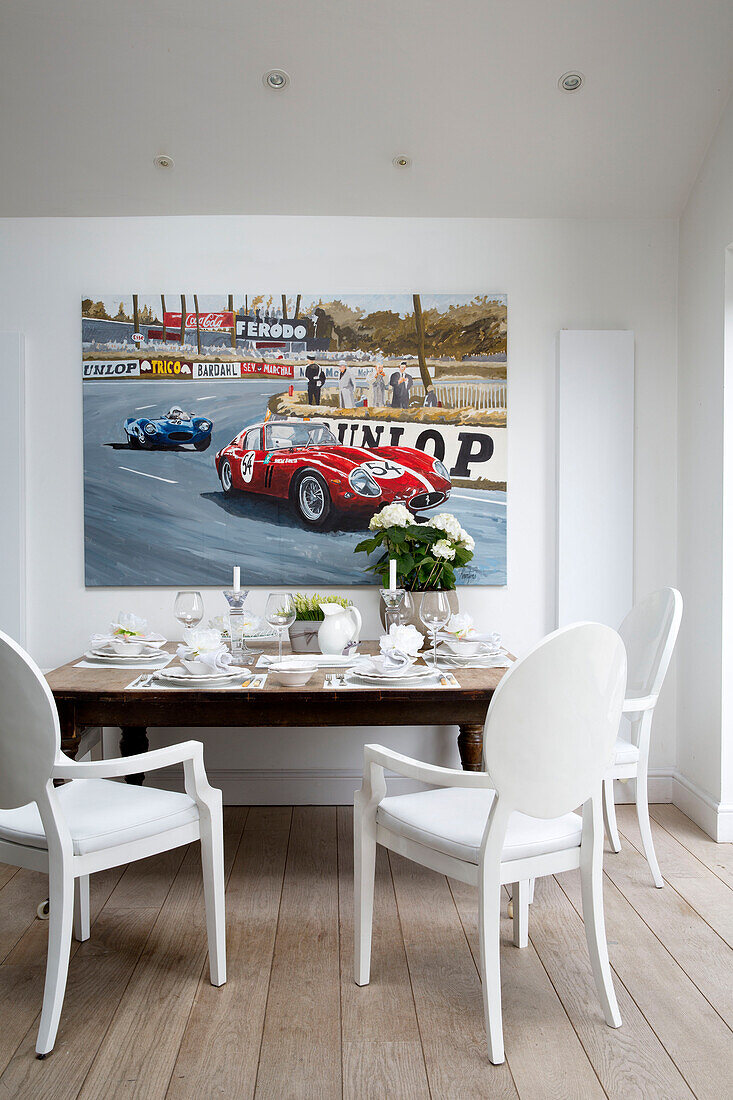 Esstisch und Stühle mit Leinwand für Autorennen in einem Londoner Stadthaus, England, UK