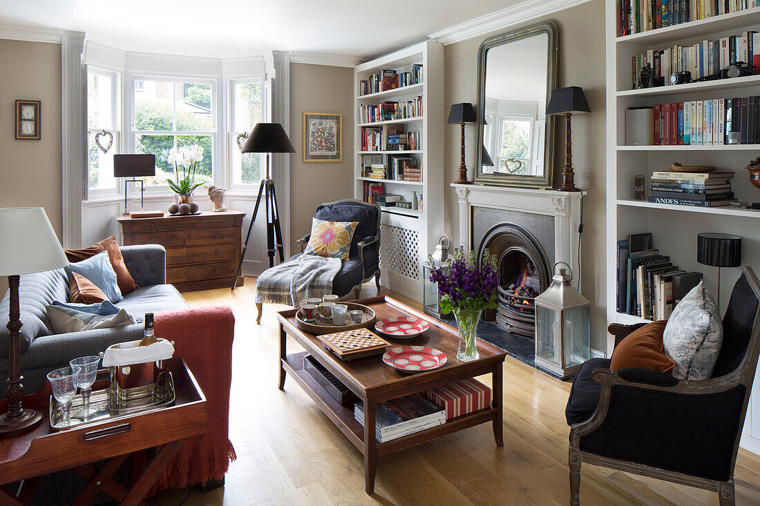 Wooden coffee table and sofa with armchairs in London home, England, UK