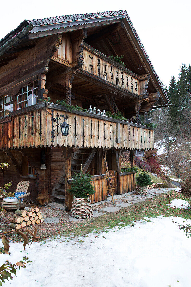 Geschnitzter Holzbalkon mit Treppe zu einem Bergchalet in Chateau-d'Oex, Waadt, Schweiz