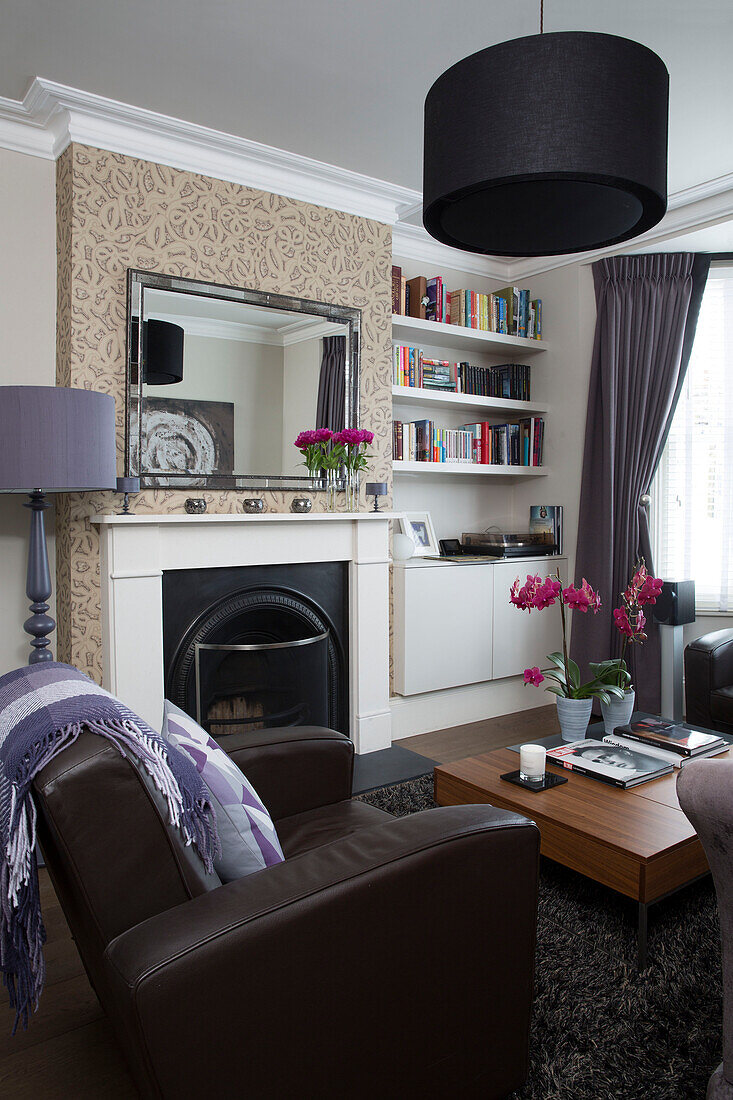 Schwarzer Lampenschirm im Wohnzimmer mit braunem Ledersessel im modernen Haus in Brighton, East Sussex, England UK