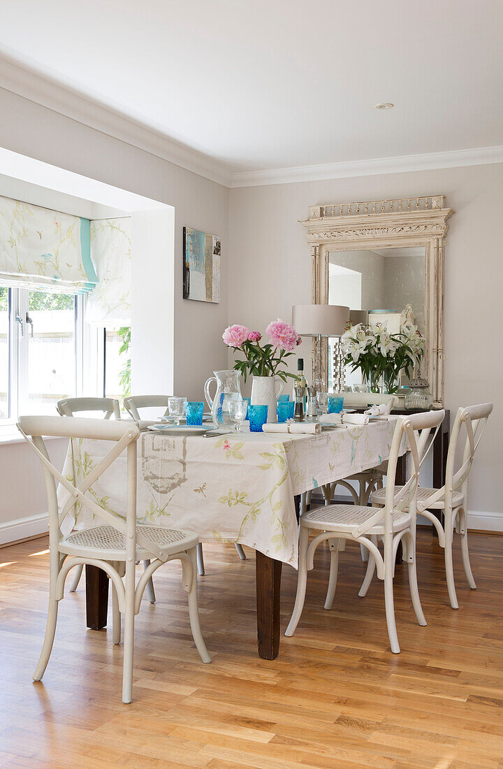 painted chairs at table in laminate dining room of London family home, England, UK