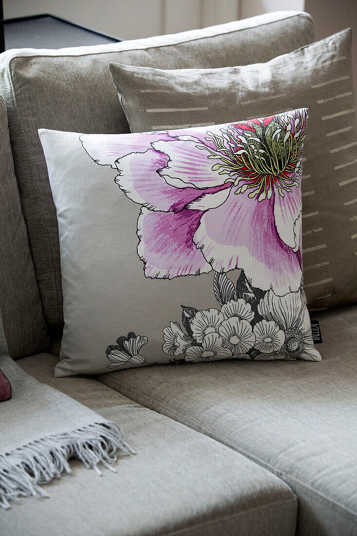 Floral cushion on corner sofa in London family home, England, UK