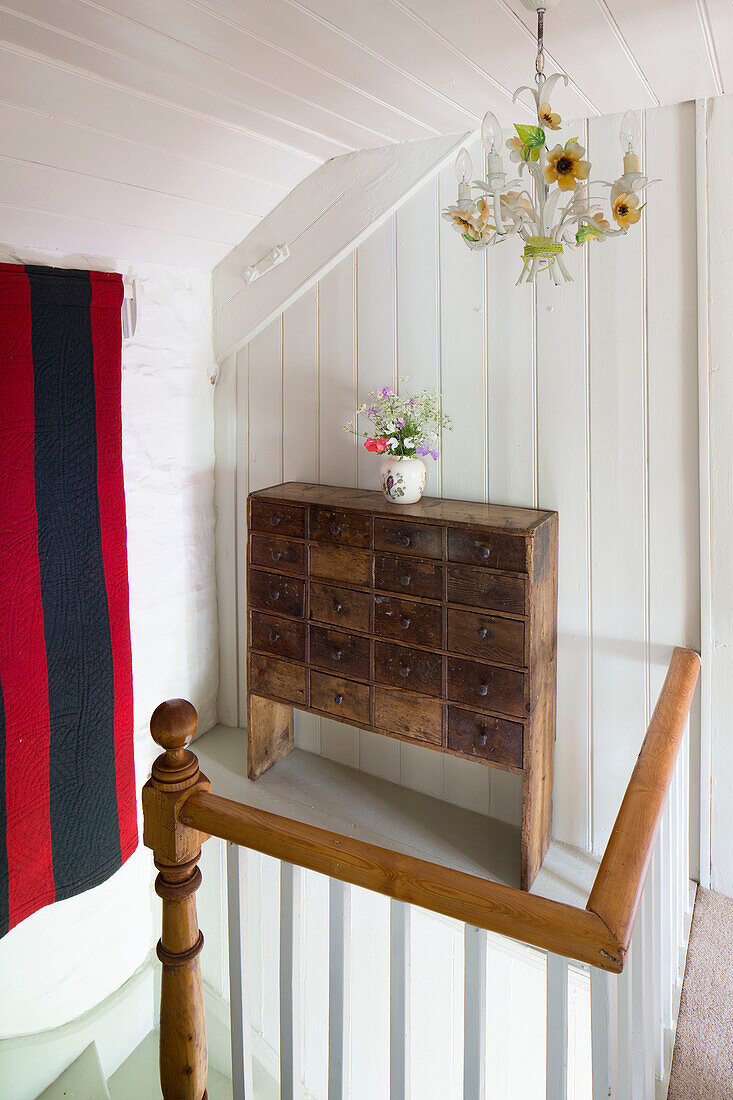 Vintage-Schubladen und gestreifte Vorhänge im Treppenhaus eines Cottages in Ceredigion, Wales, UK