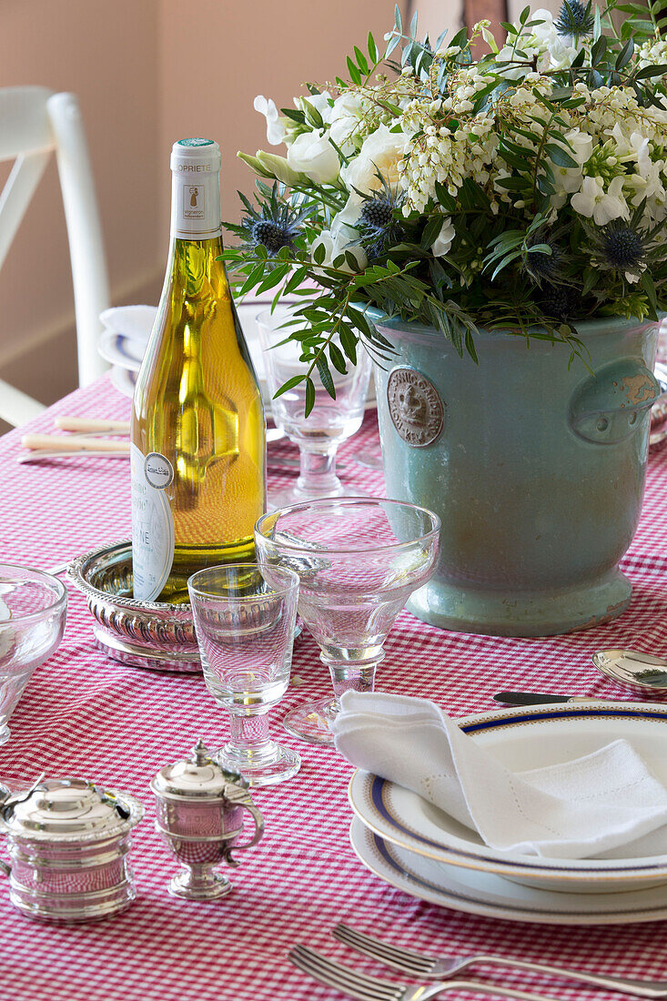 Weißwein und Schnittblumen auf einer rotkarierten Tischdecke im Speisesaal in Camber, East Sussex, England, Vereinigtes Königreich