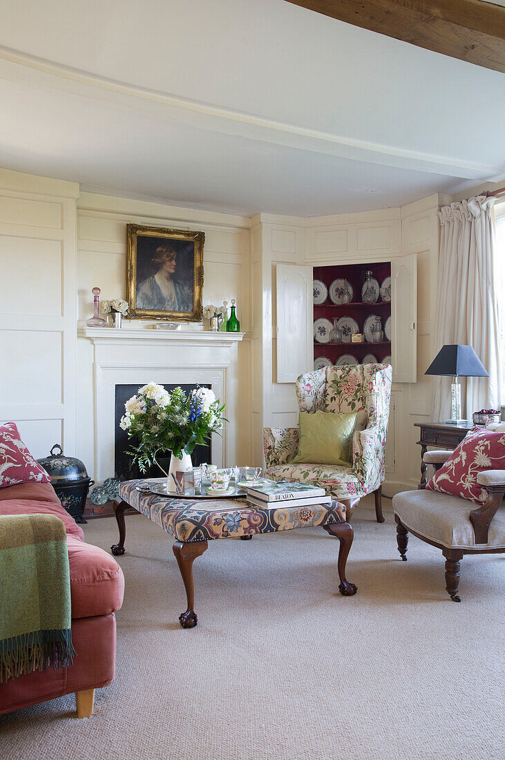 Living room seating with upholstered ottoman in Camber cottage East Sussex England UK