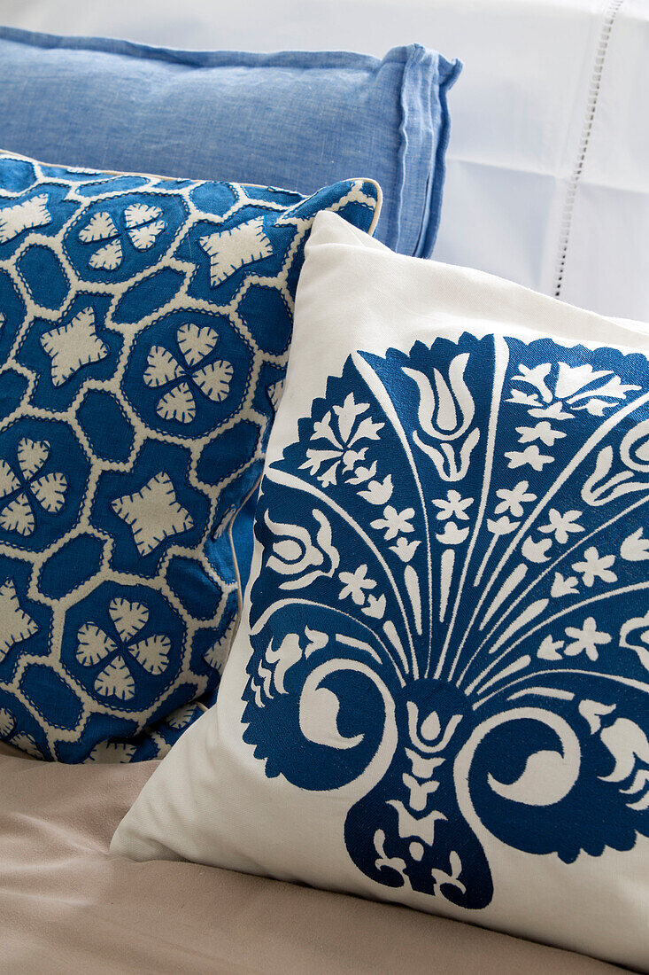 Contrasting blue and cream patterned cushions in London home, England, UK