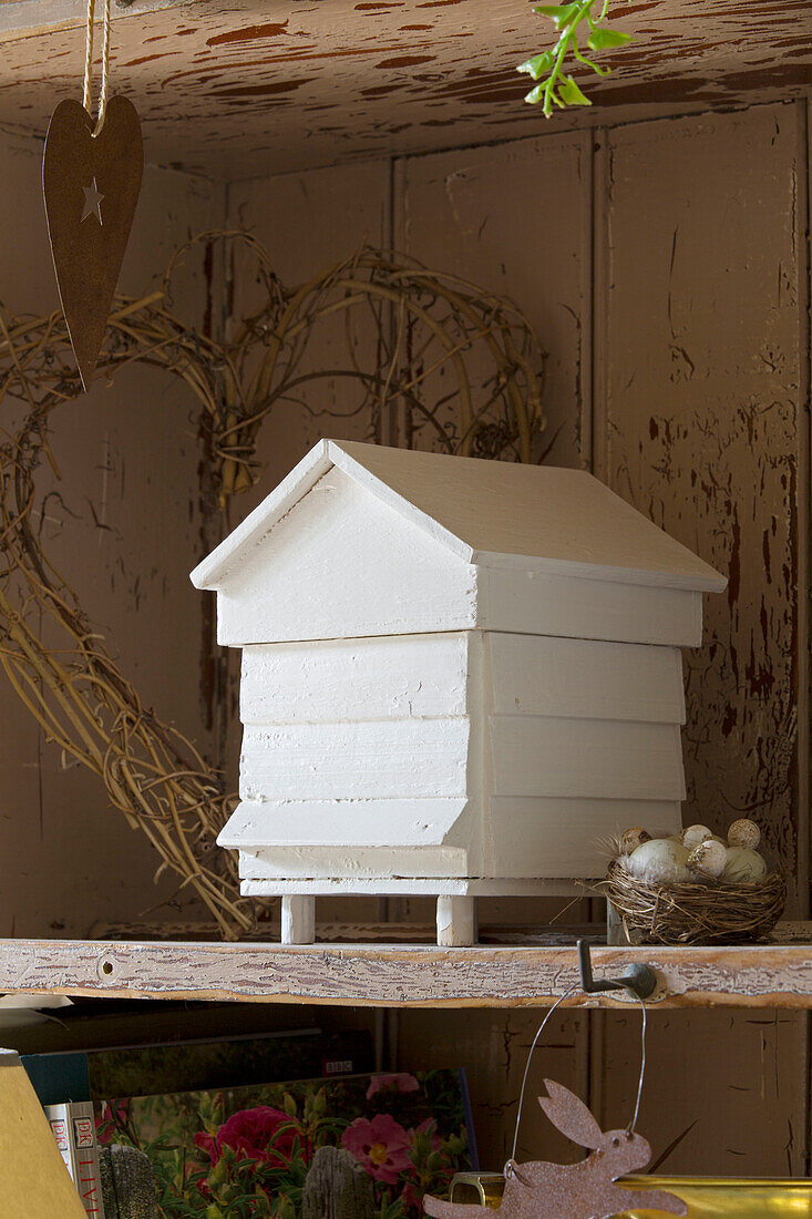 Maßstabsgetreues Modell eines Bienenstocks mit Vogelnest und Eiern auf einem Regal in einem britischen Bauernhaus