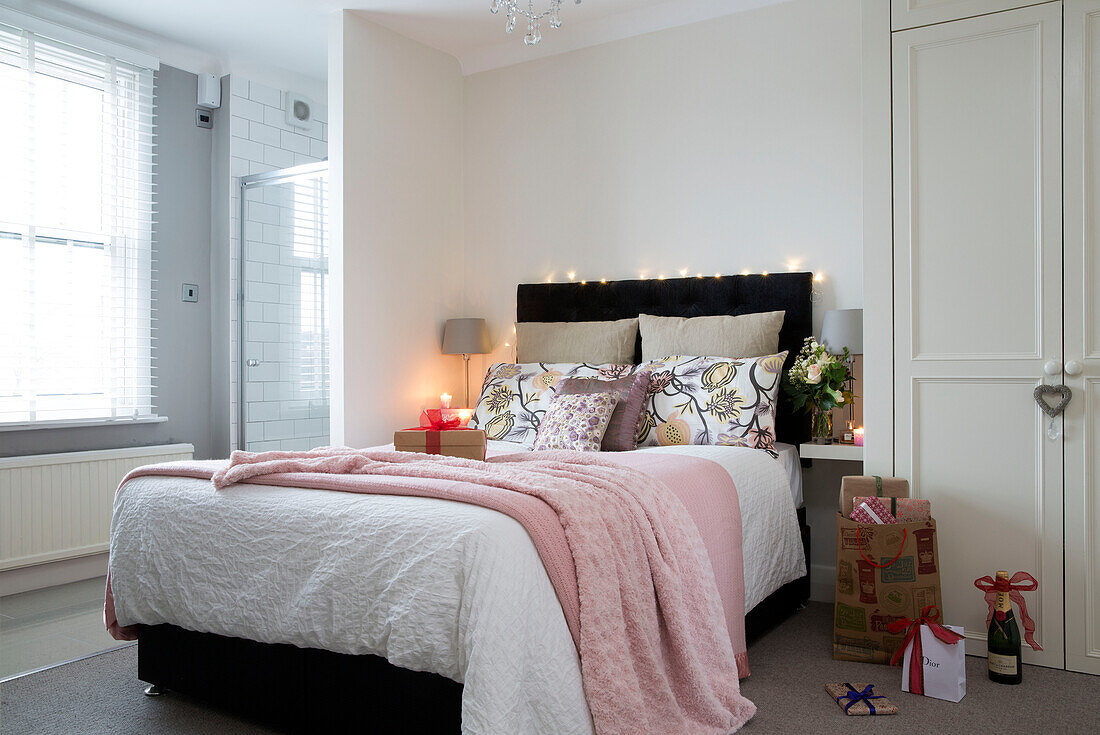 Fairylights on double bed with pink blankets in London home, England, UK